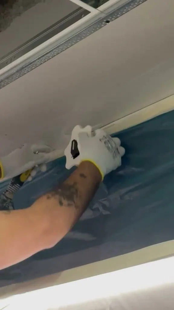 VELOBOX in uso reale in cantiere: il dispositivo tenuto a contatto con la superficie posa il velo vetro sul giunto del cartongesso