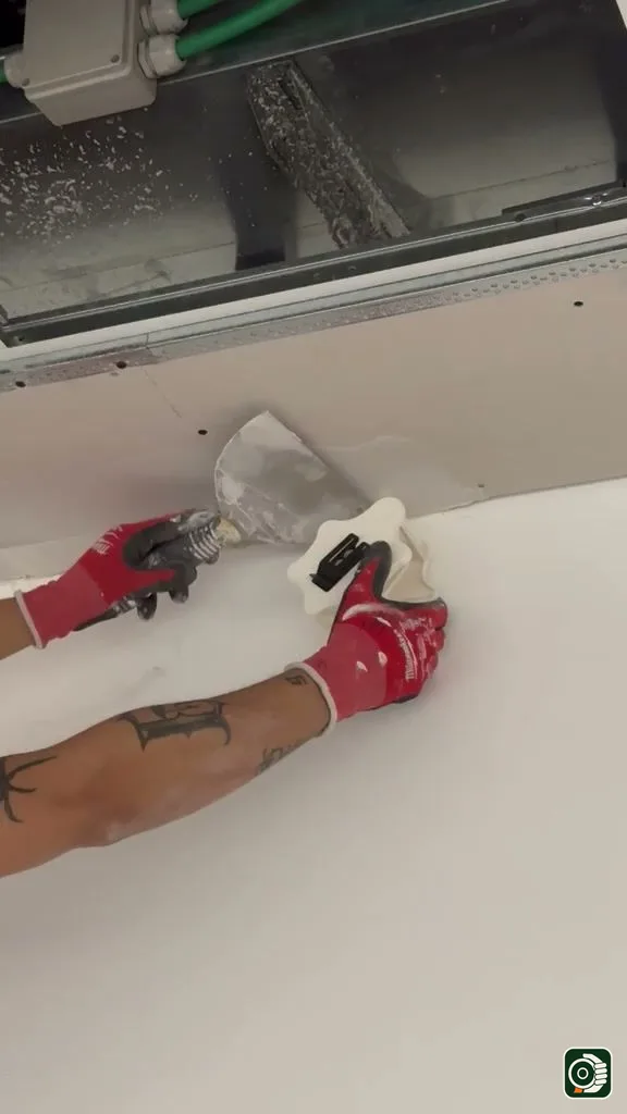 Posa reale a soffitto: VELOBOX eroga il velo vetro sul giunto mentre la spatola lo annega nello stucco