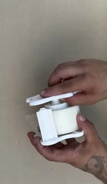 Rotolo posizionato nella scocca aperta del dispenser VELOBOX, pronto per chiudere il coperchio a stella