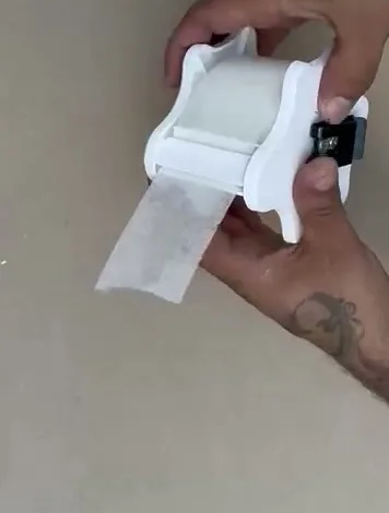 Nastro velo vetro filato fuori dalla fessura di uscita del dispenser VELOBOX