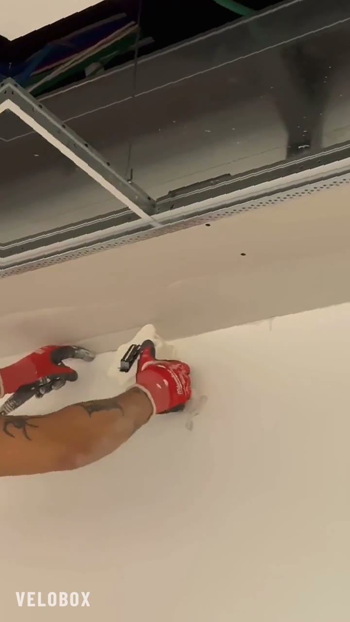 Applicazione del velo vetro su un giunto di cartongesso a soffitto in un cantiere reale